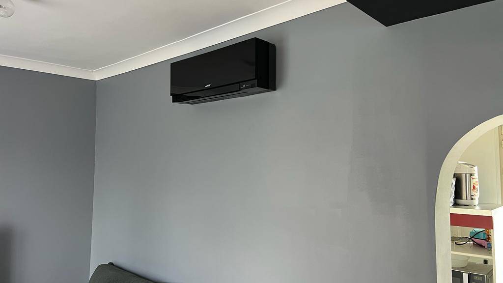 Pose d'une climatisation réversible noir de Mitsubishi Electric dans un appartement à Meaux